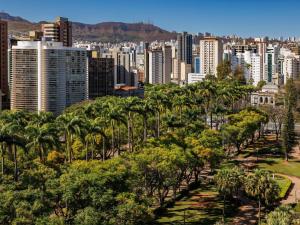 a city with palm trees in front of a city at ibis Belo Horizonte Liberdade in Belo Horizonte