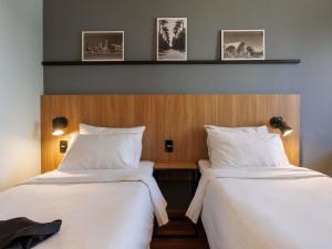 two beds sitting next to each other in a room at ibis Belo Horizonte Liberdade in Belo Horizonte