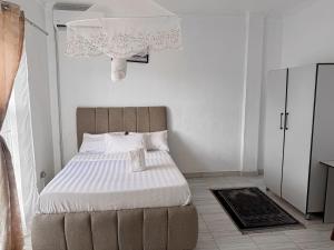 a bedroom with a large bed with white sheets at Mlambe Executive Apartments in Lilongwe