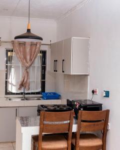 a kitchen with a table with two chairs and a stove at Mlambe Executive Apartments in Lilongwe