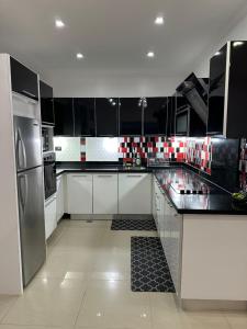 a kitchen with black and white cabinets and stainless steel appliances at Yaque Land in El Yaque