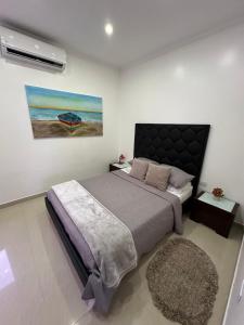 a bedroom with a bed and a painting on the wall at Yaque Land in El Yaque