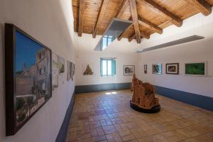 a large room with paintings on the wall and a large painting on the wall at Castello Di Postignano Relais in Sellano