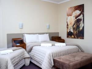 a bedroom with two beds and a painting on the wall at Park Hotel Bethlehem in Bethlehem