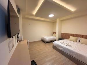 a hotel room with two beds and a flat screen tv at Full House Chiangkhan 21 in Chiang Khan