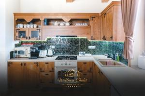 a kitchen with wooden cabinets and a stove top oven at Wellness chalet Smokovec in Vysoké Tatry