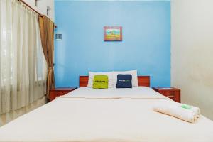 a blue bedroom with a bed with two pillows at Urbanview My Grand Hotel Bogor in Brujul +37 photos