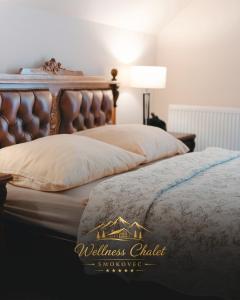 a bedroom with a bed with a leather headboard at Wellness chalet Smokovec in Vysoké Tatry