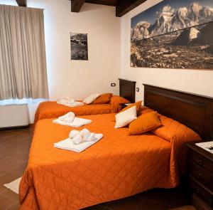 two beds in a hotel room with towels on them at Tenuta VERBICARO in Morano Calabro