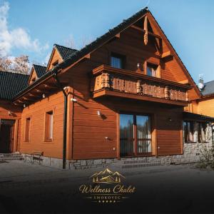 a wooden house with a balcony on top of it at Wellness chalet Smokovec in Vysoké Tatry