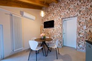 a dining room with a table and white chairs at Ca' Lodola in Borzano