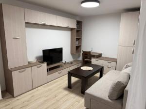 a living room with a couch and a tv and a table at Forest Hills in Kovačevica