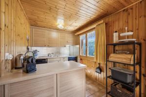 a kitchen with wooden cabinets and a counter top at Chalet Siesta OG in Bellwald