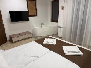 a bathroom with a bed and a tub and a sink at Forest Hills in Kovačevica