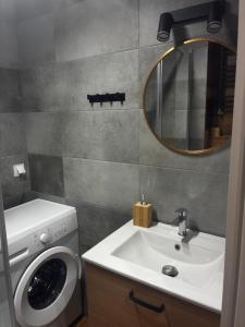 a bathroom with a washing machine and a sink at Apartament Kopernikus in Grodzisk Mazowiecki