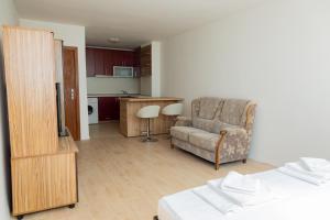 a living room with a chair and a kitchen at Антична панорама in Hisarya