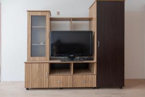 a wooden entertainment center with a flat screen tv at Антична панорама in Hisarya