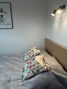 a bed with three pillows on top of it at Apartament Kopernikus in Grodzisk Mazowiecki