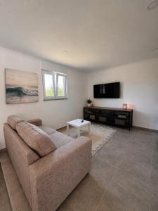 a living room with a couch and a flat screen tv at The Nook II, Lourinha in Lourinhã
