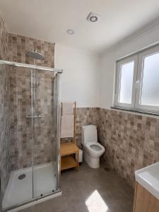 a bathroom with a toilet and a glass shower at The Nook II, Lourinha in Lourinhã