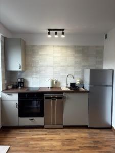 a kitchen with a refrigerator and a dishwasher at Apartament Kopernikus in Grodzisk Mazowiecki