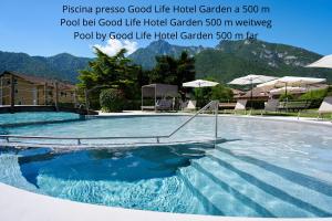a swimming pool with blue water in a resort at Residence Ledro in Ledro