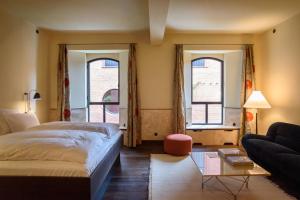 a bedroom with a bed and a couch and two windows at Hotel Frihavnen in Copenhagen +59 photos
