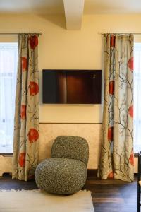 a living room with a chair and a flat screen tv at Hotel Frihavnen in Copenhagen