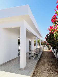 eine Terrasse mit Tisch und Stühlen in der Unterkunft Hôtel Mango GI in Saly Portudal