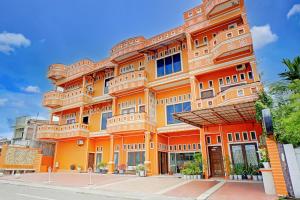 an orange building with windows on a street at Hotel O Kuta Alam Near Masjid Oman Al-Makmur Formerly Daka Hotel in Lheue
