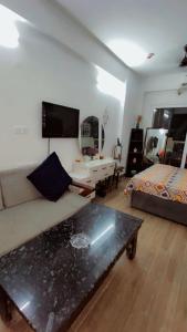 a living room with a couch and a table at Dimond Villa in Greater Noida