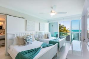 two beds in a bedroom with a view of the ocean at Designer Oceanview Penthouse & Pool - Condado in San Juan +74 photos