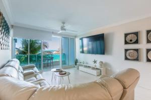 a living room with a couch and a tv at Designer Oceanview Penthouse & Pool - Condado in San Juan