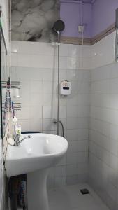a bathroom with a white sink and a shower at Js Immobilier in Abidjan