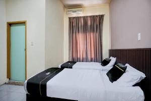 a bedroom with two beds and a window at Hotel O Kuta Alam Near Masjid Oman Al-Makmur Formerly Daka Hotel in Lheue +24 photos