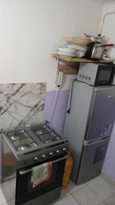 a kitchen with a stove and a refrigerator at Js Immobilier in Abidjan