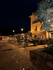 a building with a courtyard at night with lights at Ostan Hôtel Boutique in Roquebillière
