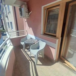 a balcony with two chairs and a table and a window at Villa Rimari in Ohrid