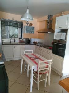 a kitchen with white cabinets and a table and chairs at chambre Chez sylvie in Allaire