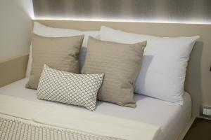 a group of pillows sitting on top of a bed at Pansion Garni in Bihać