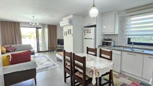 a kitchen and living room with a table and chairs at Villa Zümrüt in Ortaca