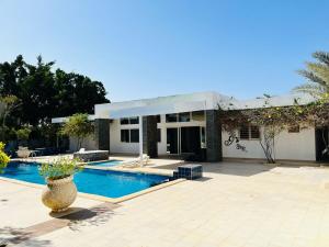 ein Haus mit einem Swimmingpool davor in der Unterkunft Hôtel Mango GI in Saly Portudal