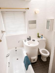 a white bathroom with a toilet and a tub and a sink at Dwarskersbos,Skilliepark in Velddrif +15 photos
