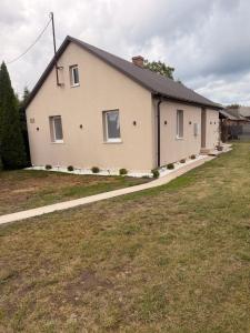 a house with a grass yard in front of it at Dom nad jeziorem Krasne in Krasne