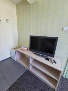 a flat screen tv sitting on top of a entertainment center at The Yellow House in Ahtopol +36 photos