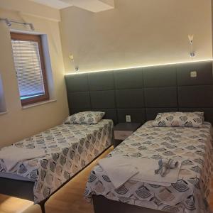 a bedroom with two beds and a window at Villa Rimari in Ohrid