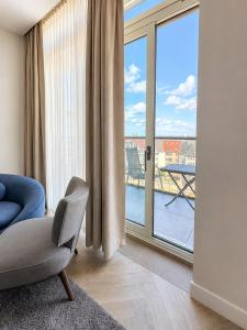 a living room with a chair and a large window at SOLWO Suites Berlin Charlottenburg in Berlin