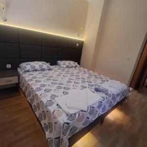 a bedroom with a bed with a white and blue comforter at Villa Rimari in Ohrid