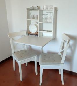 a white table and two chairs and a shelf at Alpina Sanico in Toscolano Maderno +14 photos