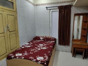 a small room with a bed and a window at Sri Sai Lodge in Palni